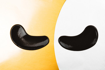 Black eye patches with collagen on bright background