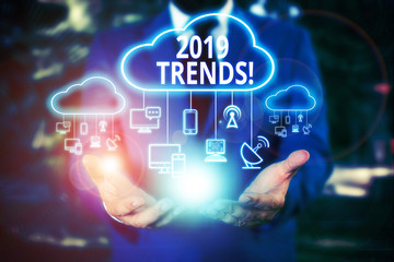 Fototapeta premium Writing note showing 2019 Trends. Business concept for general direction in which something is developing or changing Male wear formal work suit presenting presentation smart device