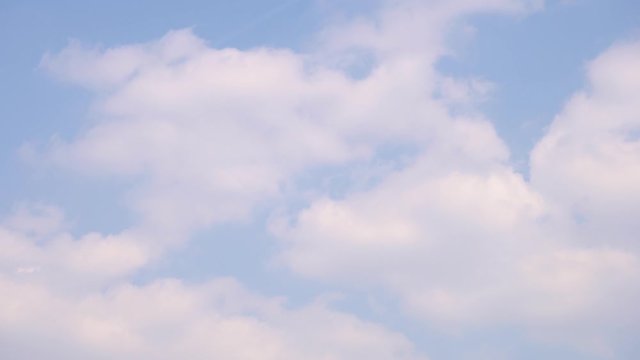 Plane flies through the wonderful, incredibly beautiful, white fluffy clouds. 4K Time Lapse. Silhouette of a jet. Airplane leaves a trail on a blue Sunny day sky. Good weather. Ultra HD. TimeLapse.