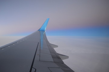 wing of an airplane flying above the clouds