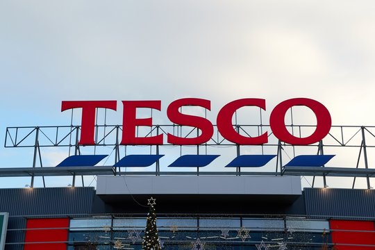 BRNO, CZECHIA - NOVEMBER 24, 2019: Large sign of a Tesco supermarket, some christmas decoration visible below. Tesco is the third-largest retailer in the world measured by revenues.