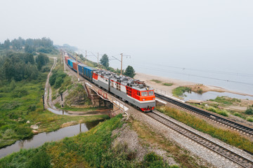 Freight train on railroad bridge of Trans-Siberian Railway on shore of Lake Baikal. East Siberian Railway in Buryatia, Siberia, Russia