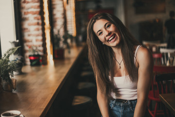 Beautiful woman posing for the camera sitting in a cafe.
