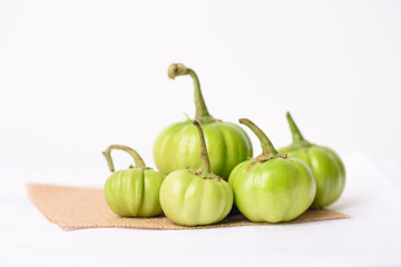 Close up of organic raw green tomato on a white background