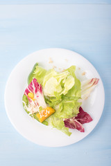 Healthy vegetable salad bowl on blue background