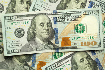 Background of 100 dollar bills. Close-up. Portrait of Benjamin Franklin on the hundred dollar banknote. In God we trust.