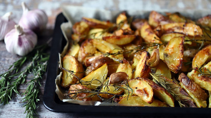 Selective focus. Homemade baked rustic potato with garlic and rosemary.