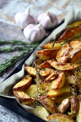 Selective focus. Homemade baked rustic potato with garlic and rosemary.