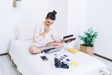 Pensive female working at laptop at home