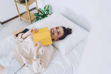 Young woman reading diary and laughing