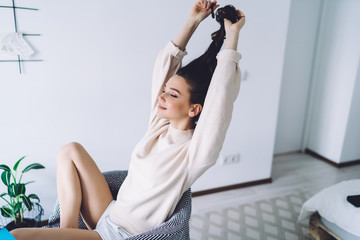 Obraz premium Becalm young woman resting in easy armchair at bedroom