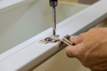 Adjusting fixing cabinet on white wooden doors hinge