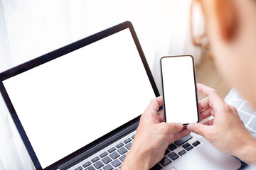 mockup image blank screen computer,cell phone with white background for advertising text,hand man using laptop texting mobile contact business search information on desk in office.marketing and design