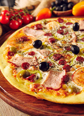 Meat pizza on wooden table close up