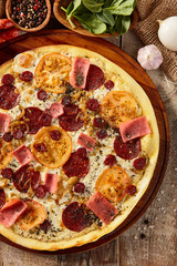 Meat and tomato pizza on wooden table