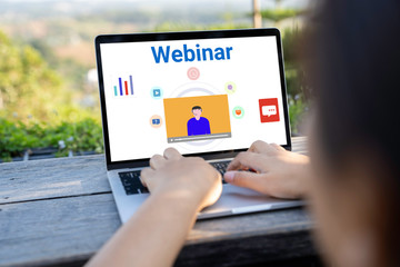 Person using a laptop computer for online training webinars. E-learning browsing connection and cloud online technology webcast concept. Laptop mockup with clipping path on screen.