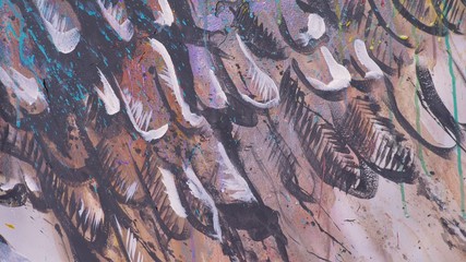 Artist designer draws an eagle on the wall. Craftsman decorator paints a picture with acrylic oil color brush. Close-up dark magic cinematic look. Painter dressed in a paint coat. Indoor.