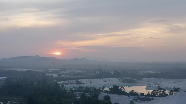 Aerial dolly out view of Kaolin Lake mine pit area cloudy sky at sunrise Belitung island, Bangka Indonesia, reveal shot