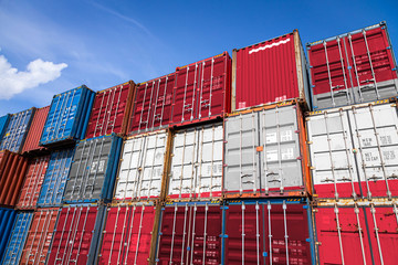 Fototapeta premium The national flag of Austria on a large number of metal containers for storing goods stacked in rows on top of each other. Conception of storage of goods by importers, exporters