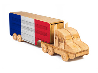 Close-up of a wooden toy truck with a painted national flag France. The concept of export-import,transportation, national delivery of goods