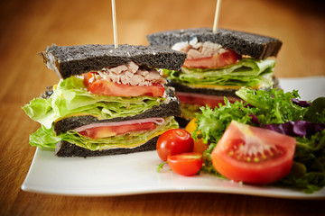 Black bread chicken sandwich with salad 