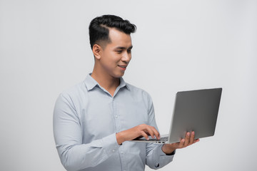 Happy young Asian software developer with laptop in his hands
