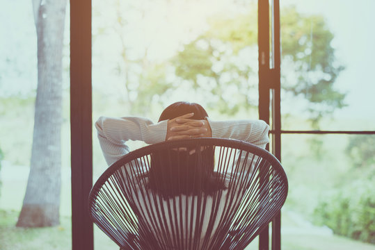 Woman sitting with hands on her head on modern chair in bedroom,Relaxing time,Back view