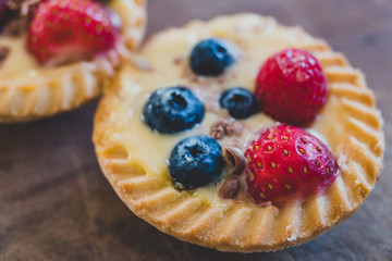berries custard and chocolate pastries on cutting board