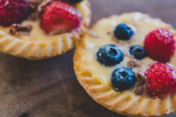 berries custard and chocolate pastries on cutting board