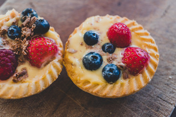berries custard and chocolate pastries on cutting board