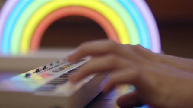 Soft focus side view of kids hands playing a small keyboard