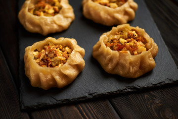 Dumplings with vegetable: Dimsum, Jiaozi, Momo, Ha Gao on dark wood background.