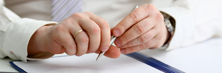 Male arm in suit and tie hold silver pen