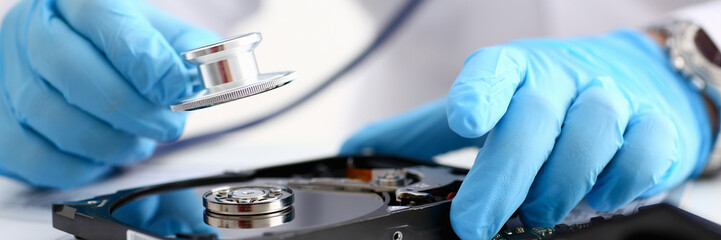 A male repairman wearing blue gloves
