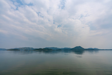 Fototapeta premium beautiful blue sky green forest mountains lake view at Kaeng Krachan National Park, Thailand. an idea for backpacker hiking on long weekend or a couple, family activity camping holiday relaxing