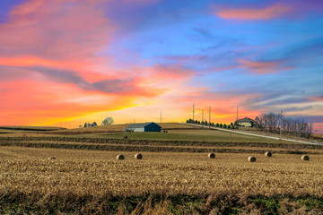 Twilight sunset over a golden field in the middle of Iowa along route 80 in the USA. - obrazy, fototapety, plakaty