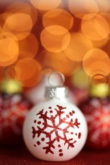 Christmas festive background.White christmas ball set with snowflake on red glitter background with yellow blurred bokeh.Winter holidays.Christmas shiny wallpaper.