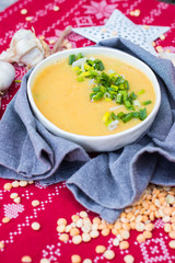Peas soup. Hot yellow creamy homemade soup with peas and green onion sprouts on winter Christmas or Xmas background. Vegan and vegetarian food. 