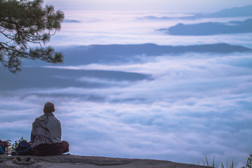 woman sitting on top of mountain with sea of mist
