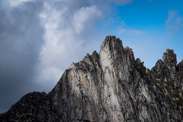 Sunlight illuminating jagged mountain summit up close