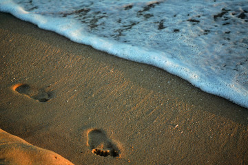waves on beach with footprints
