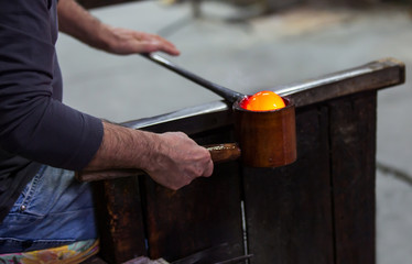 Glass blower at work shaping molten glass, Murano, Venice, Italy