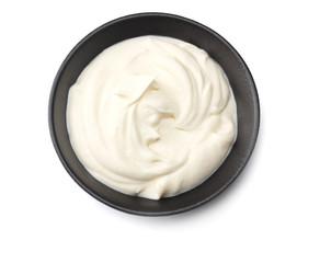 sour cream in black bowl isolated on white background. top view