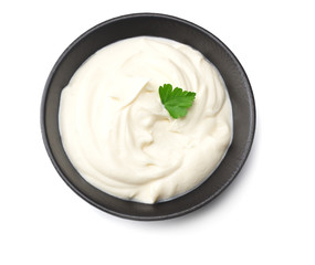 sour cream in black bowl isolated on white background. top view