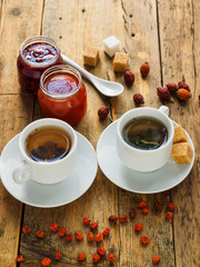 Two cups of tea and jam on a wooden table. Tea in a cozy atmosphere