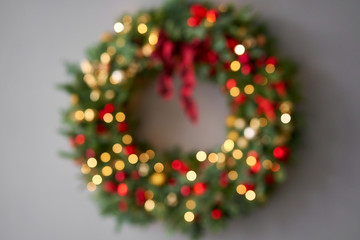 Beautiful festive wreath of fresh spruce on Gray wall. Xmas circlet with red and gold ornaments and balls. Christmas mood.