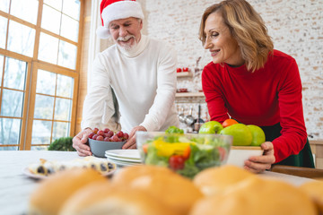 Joyful bearded male person putting bowl on the table