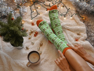 Feet in christmas socks near the Christmas tree - 307305184