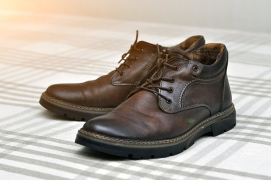 Men's insulated brown shoes made of genuine leather and with fur with lacing.