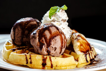 Waffle topped with chocolate ice cream , banana and wipe cream
